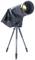 Teleskop na trójnożnym statywie, z czarną osłoną. Odpowiedni do obserwacji nieba. Brak dalszych widocznych szczegółów.