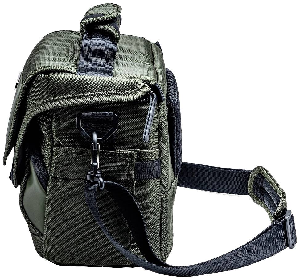 Oliwkowozielona torba na aparat fotograficzny z czarnym paskiem na ramię, klapką i kilkoma kieszeniami zamykanymi na zamek, sfotografowana z boku.