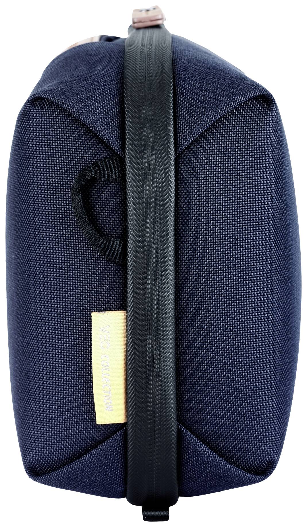 Ciemnoniebieska torba z czarnym zamkiem błyskawicznym i uchwytem bocznym. Żółta etykieta z napisem 'AEROSPACE'.