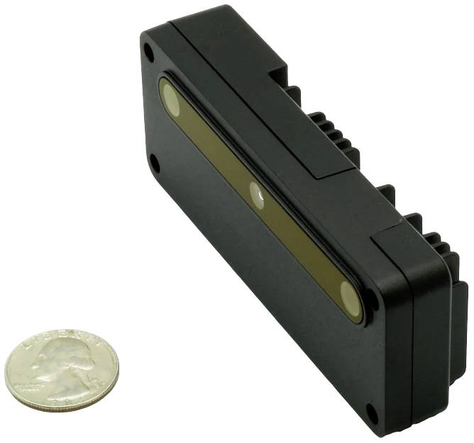 Czarny prostokątny sensor z dwoma okrągłymi soczewkami i małym, okrągłym srebrnym obiektem, który jest monetą.