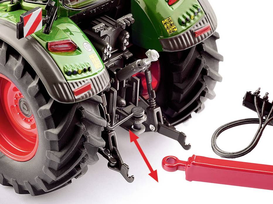 Zielony traktor z czerwonymi kołami przedstawia ujęcie z bliska tylnej części. Czerwona belka zostaje podłączona do mechanizmu holowniczego.