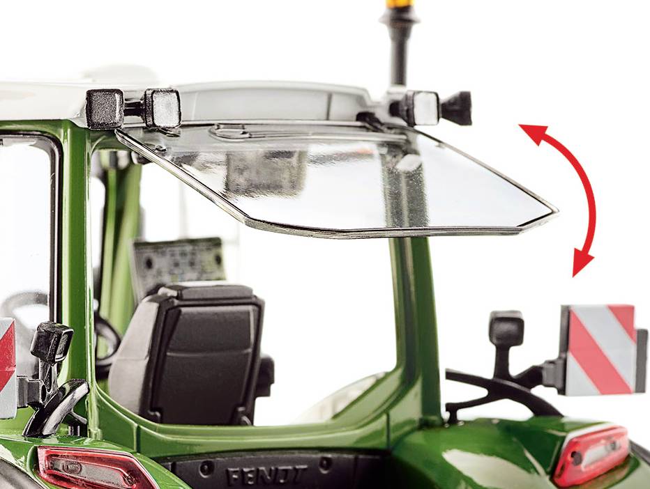 Zielony traktor z otwartym oknem i pomarańczową lampą ostrzegawczą. Po prawej i lewej stronie zamocowane są dwa znaki ostrzegawcze.