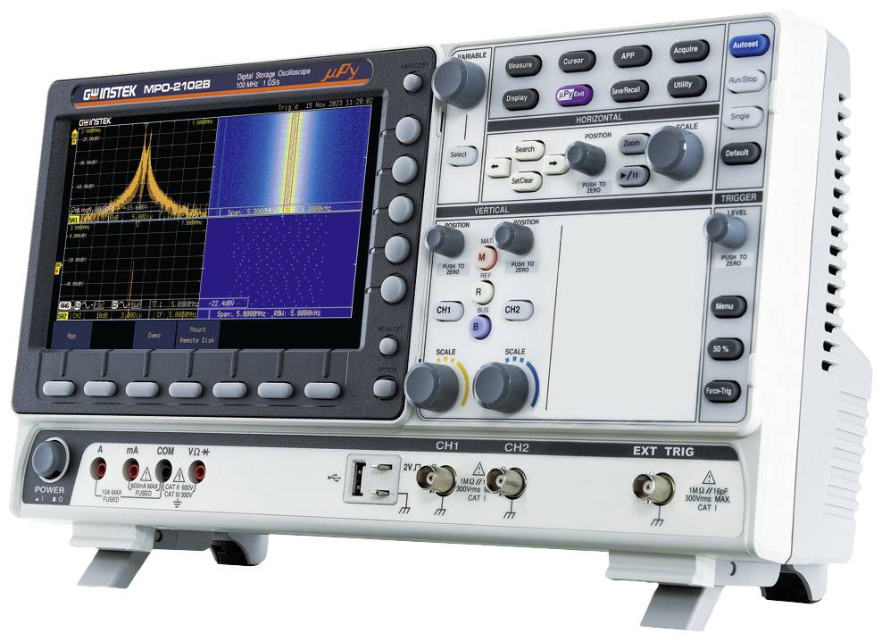 Cyfrowy oscyloskop z ekranem wyświetlającym spektrum częstotliwości i kształt sygnału. Dostępne są przyciski i złącza do obsługi urządzenia.