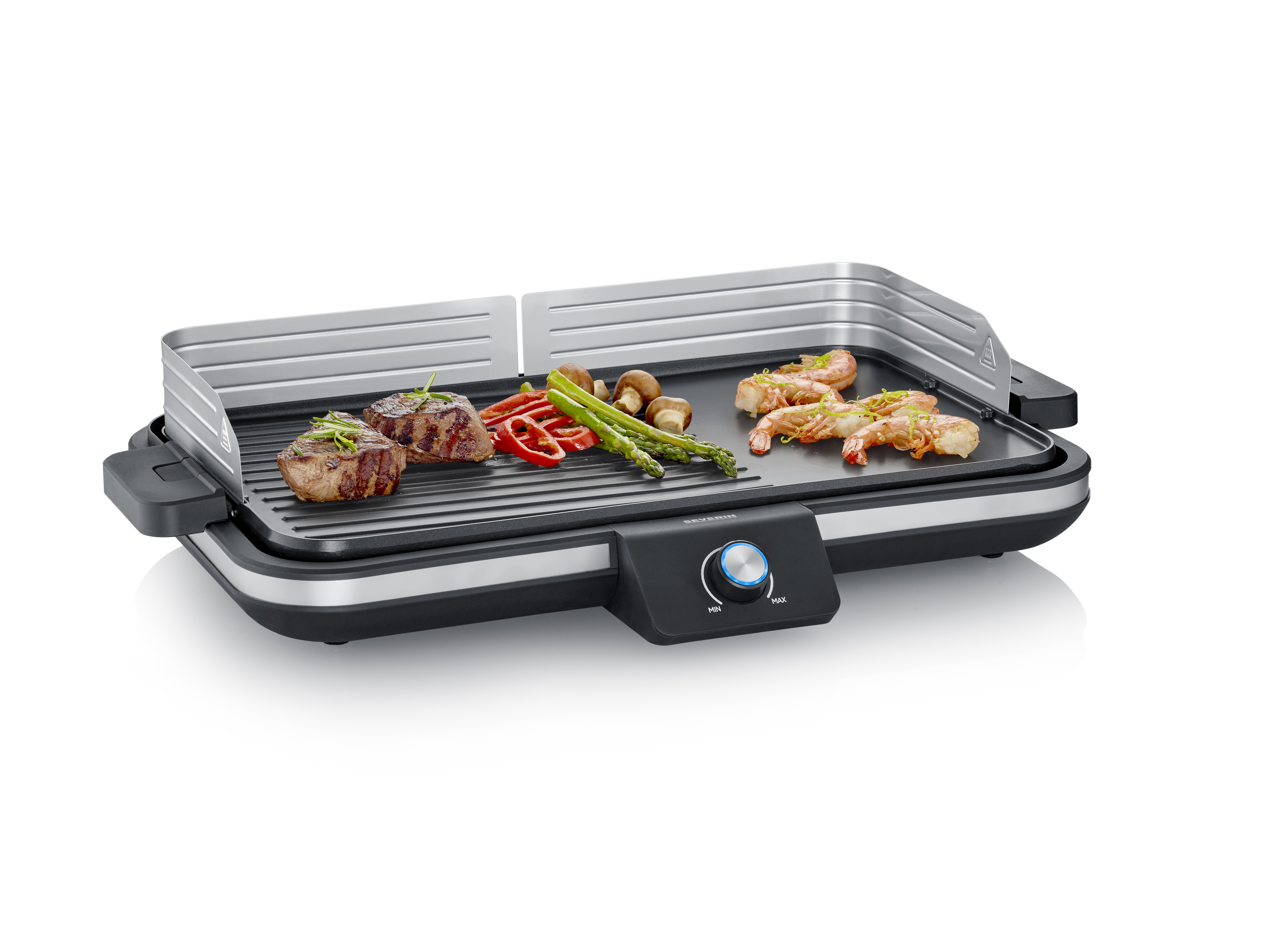 Elektryczny grill stołowy z kawałkiem steku, papryką, szparagami, pieczarkami i krewetkami na powierzchni grillowej. Grill posiada pokrętło regulacyjne.