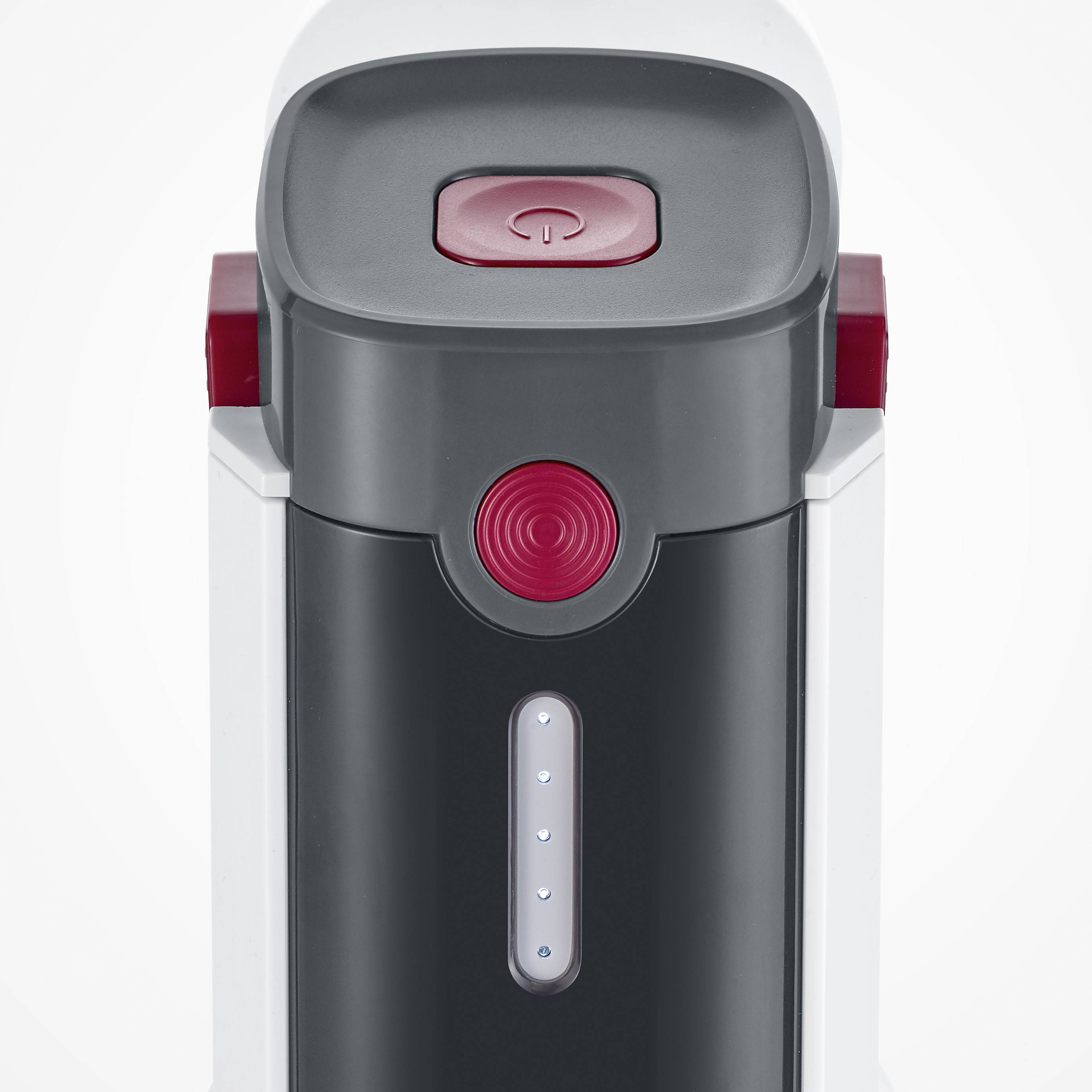 Ekspres do kawy widziany z góry, z czerwonym przyciskiem sterowania i lampkami kontrolnymi na przedniej ściance.