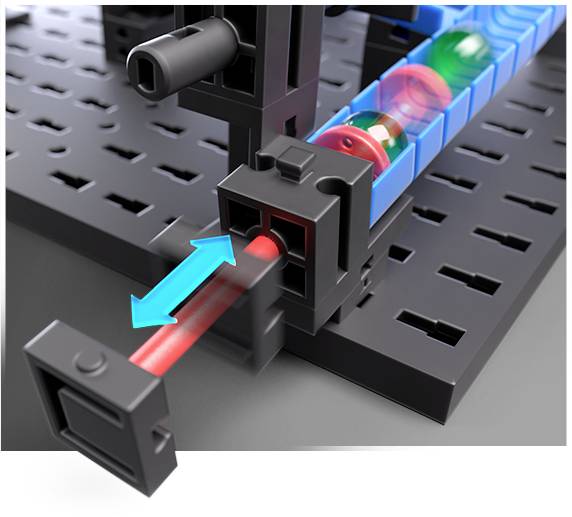 Zbliżenie czarnego mechanicznego systemu wtykowego z niebieskimi i czerwonymi elementami łączącymi, prezentujące kierunek ruchu systemu.