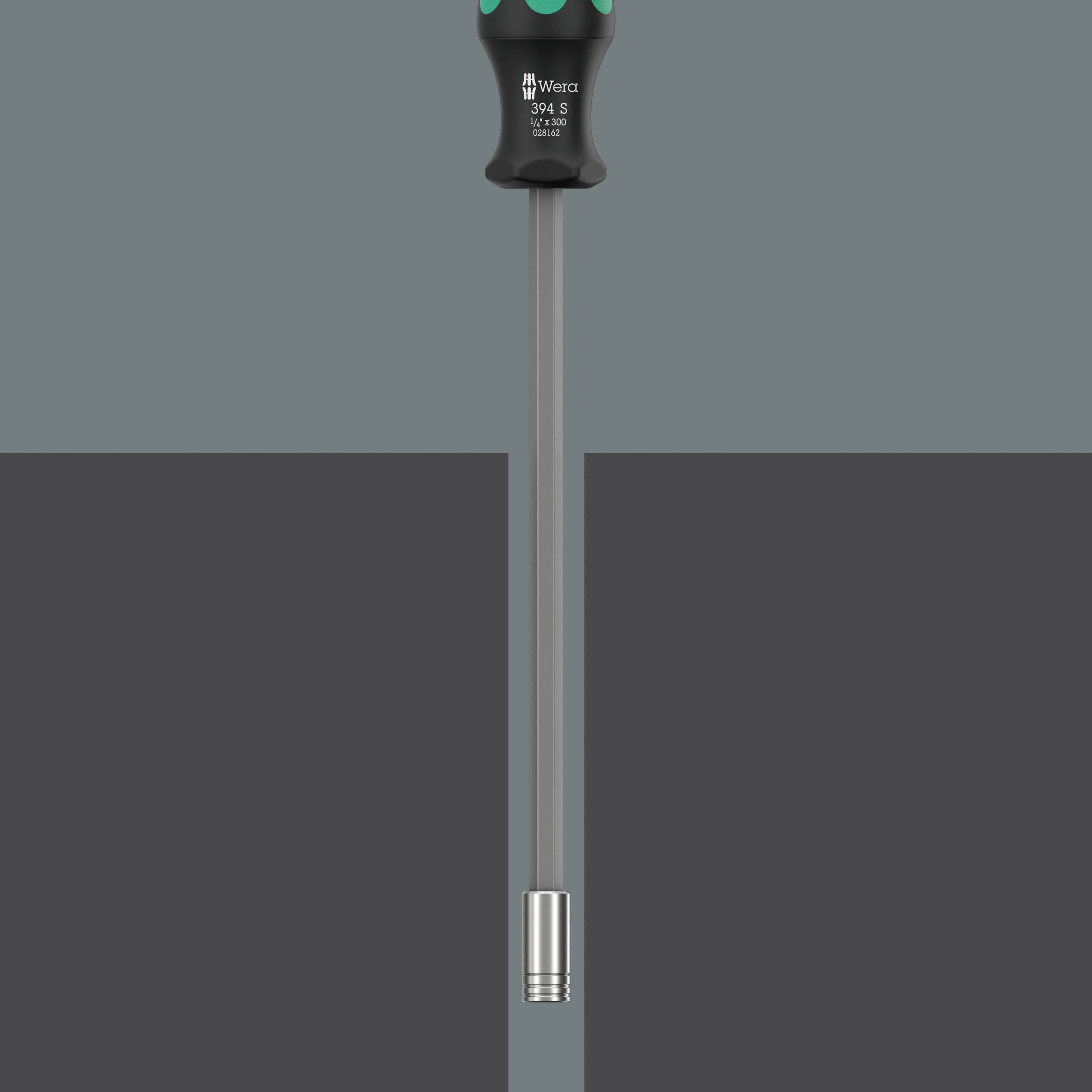 Wkrętak z szarym uchwytem, długim trzpieniem i metalowym czubkiem, przedstawiony pionowo na szarym tle.