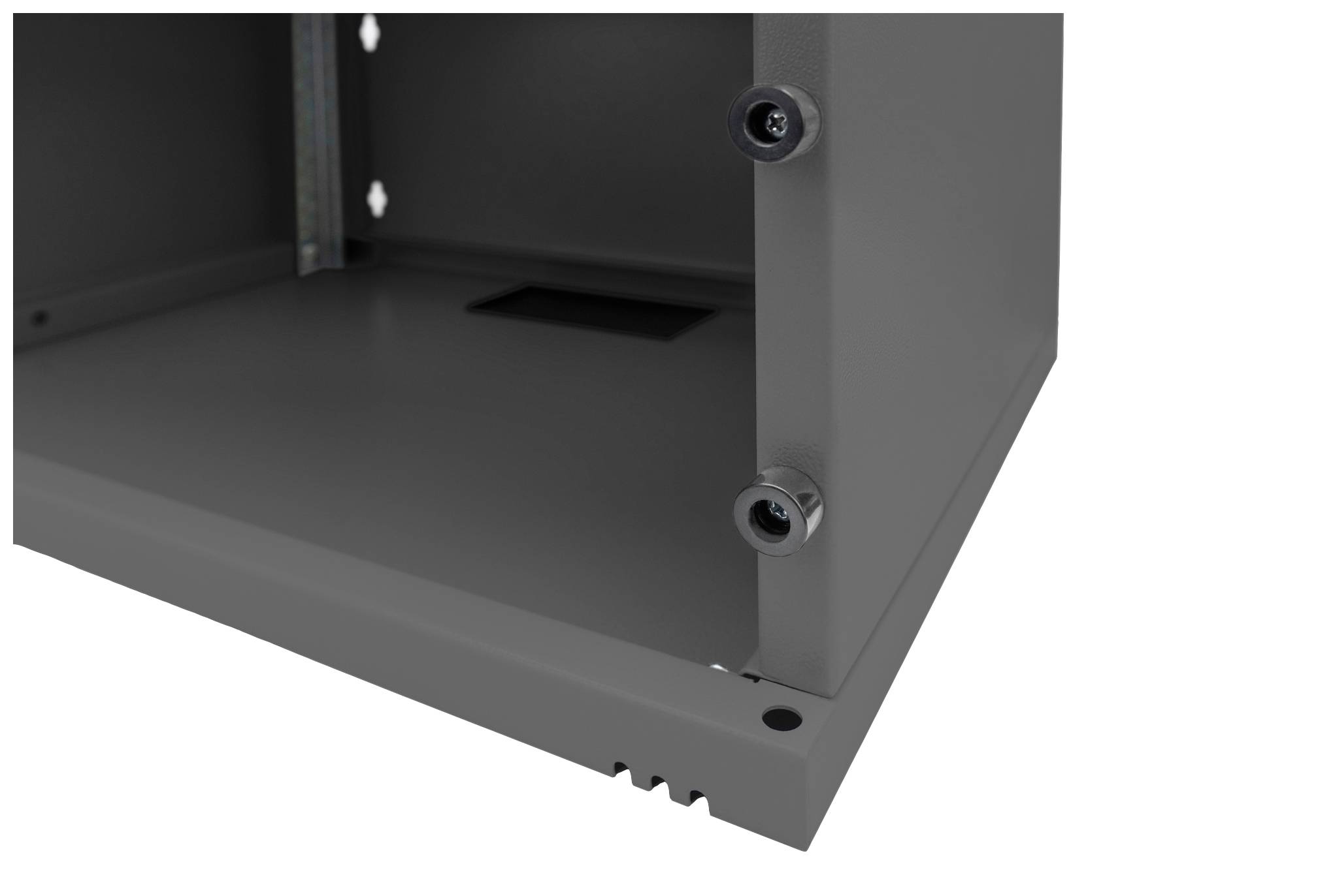 Róg szarej metalowej obudowy z dwoma widocznymi śrubami i małym otworem w tle.