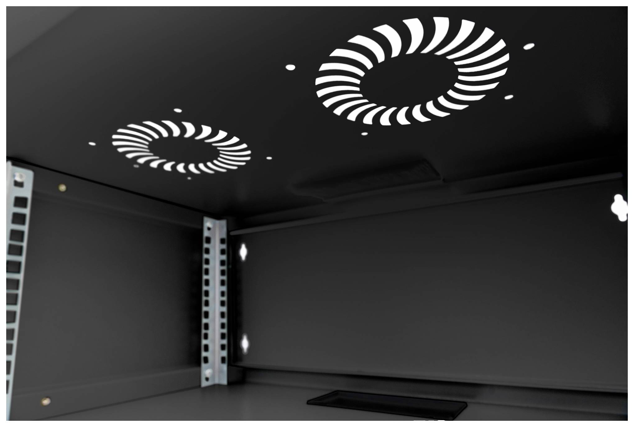 Czarny wewnętrzny przestrzeń obudowy metalowej z dwoma okrągłymi otworami wentylacyjnymi na górnej powierzchni, otoczona ramką i śrubami.