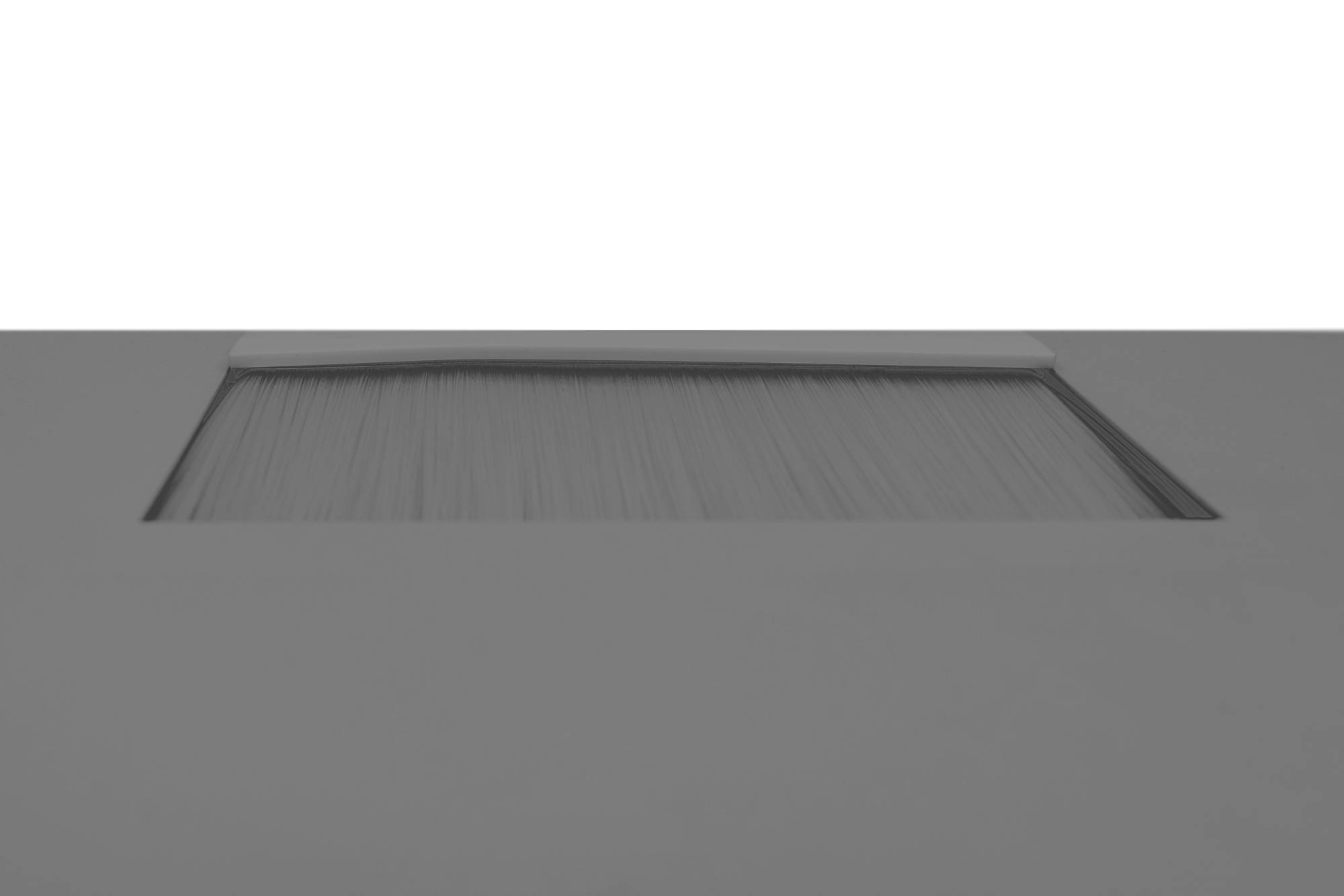 Szara brama z poziomymi lamelkami na tle białego nieba.