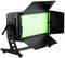 Czarny reflektor LED z zielonym światłem, otoczony regulowanymi klapami do kontroli świateł, stoi na statywie.