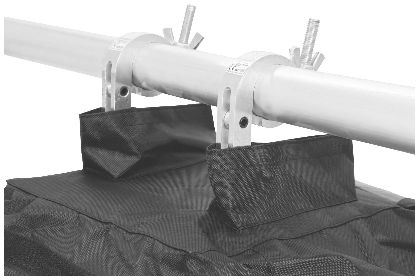 Metalowy pręt jest przymocowany za pomocą dwóch zacisków do czarnego plandeki. Śruby na zaciskach umożliwiają regulację.