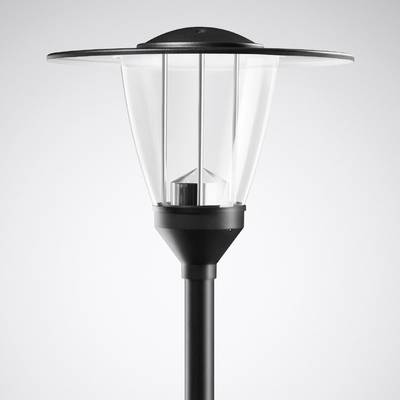 Nowoczesna lampa uliczna z przezroczystym szkłem i czarną metalową ramą stoi pionowo na szarym tle.