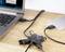 Hub USB z czterema urządzeniami: laptop, zewnętrzny dysk twardy, pendrive i przewód. Prezentuje łączność i funkcjonalność concentratora.