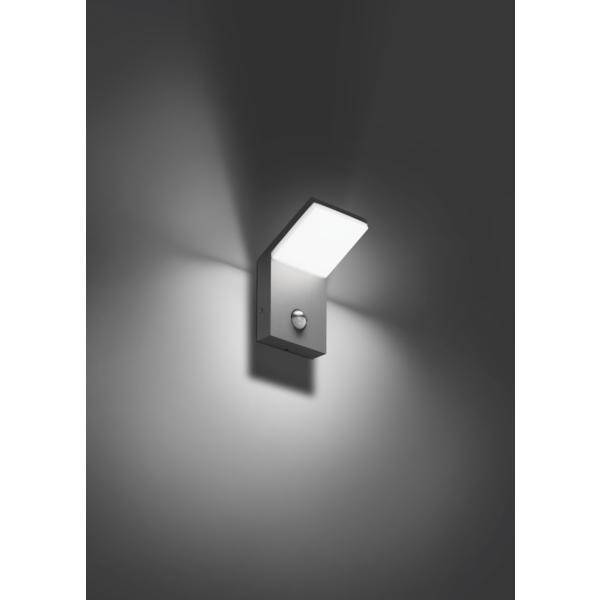 Kinkiet o nowoczesnym designie oświetla fragment ściany. Lampa posiada prostokątny klosz i czujnik ruchu.
