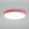 Okrągła, biała lampa sufitowa z czerwoną poświatą na obrzeżach, oświetlająca sufit w nowoczesnym designie pomieszczenia.