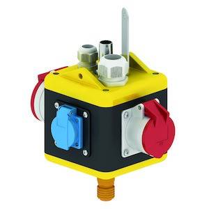 Żółte, czarne i czerwone urządzenie elektryczne w kształcie sześcianu z wieloma gniazdami i przyłączami.