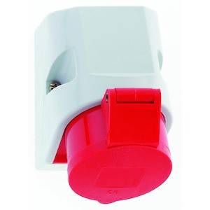 Białe urządzenie elektryczne z wyróżnionym czerwonym przełącznikiem lub przyciskiem. Wygląda na adapter wtyczkowy.