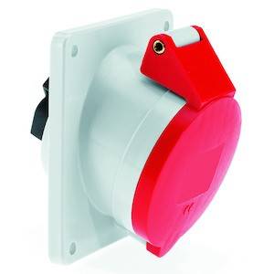 Przemysłowe gniazdo elektryczne z czerwoną pokrywą, zamontowane na białej obudowie. Służy zapewnieniu bezpiecznego połączenia elektrycznego w środowiskach przemysłowych.