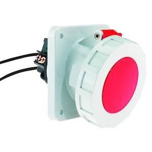 Duży czerwony przycisk bezpieczeństwa, zainstalowany na białej obudowie. Dwa przewody są podłączone z tyłu.