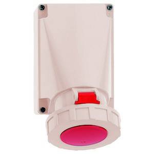 Duży czerwony przycisk na płycie ściennej, prawdopodobnie wyłącznik awaryjny, często używany do zatrzymywania maszyn.