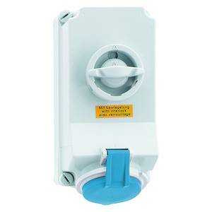 Białe, prostokątne urządzenie elektryczne z pokrętłem na górze i niebieskim gniazdem na dole. Żółta etykieta z napisem 'Z blokadą'.