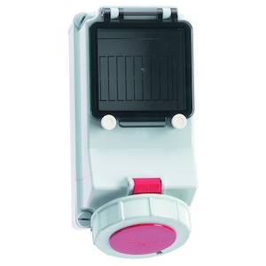 Białe elektryczne naścienne pudełko rozdzielcze z czerwonym przyciskiem i czarną klapką. Odpowiednie do podłączenia przewodów.