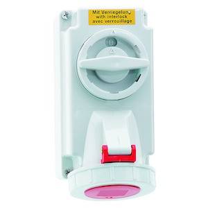 Przemysłowy przełącznik w białym kolorze z czerwoną dźwignią. Na górze żółta etykieta z napisem: 'Z blokadą, with interlock, avec verrouillage'.