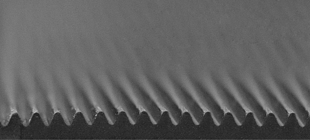 Zbliżenie zazębionej krawędzi, prawdopodobnie ostrza piły. Ostre zęby są rozmieszczone w równych odstępach.