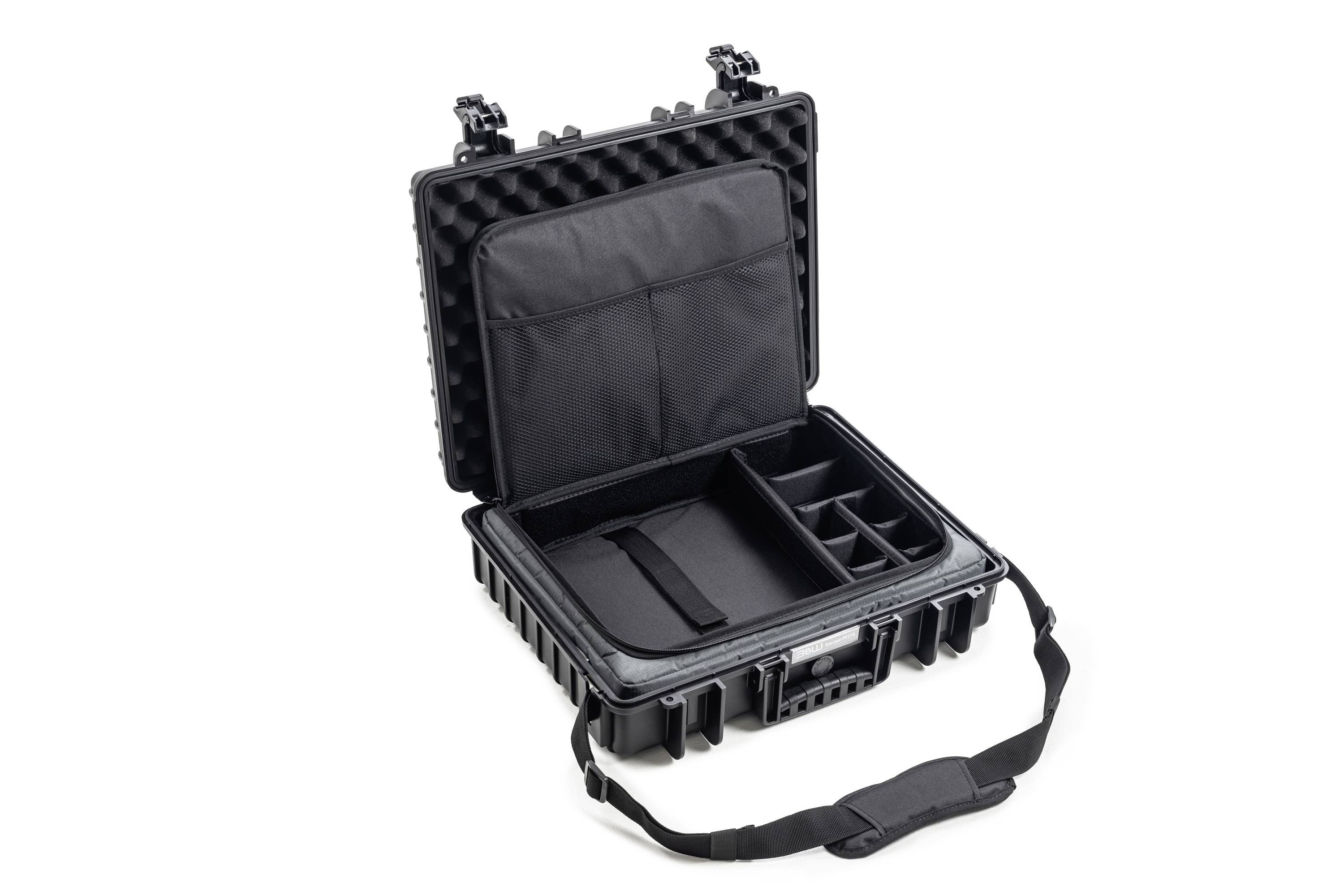 Czarny, otwarty twardy kufer z przegródkami i wyściółką do bezpiecznego transportu. Wyposażony w pasek na ramię.