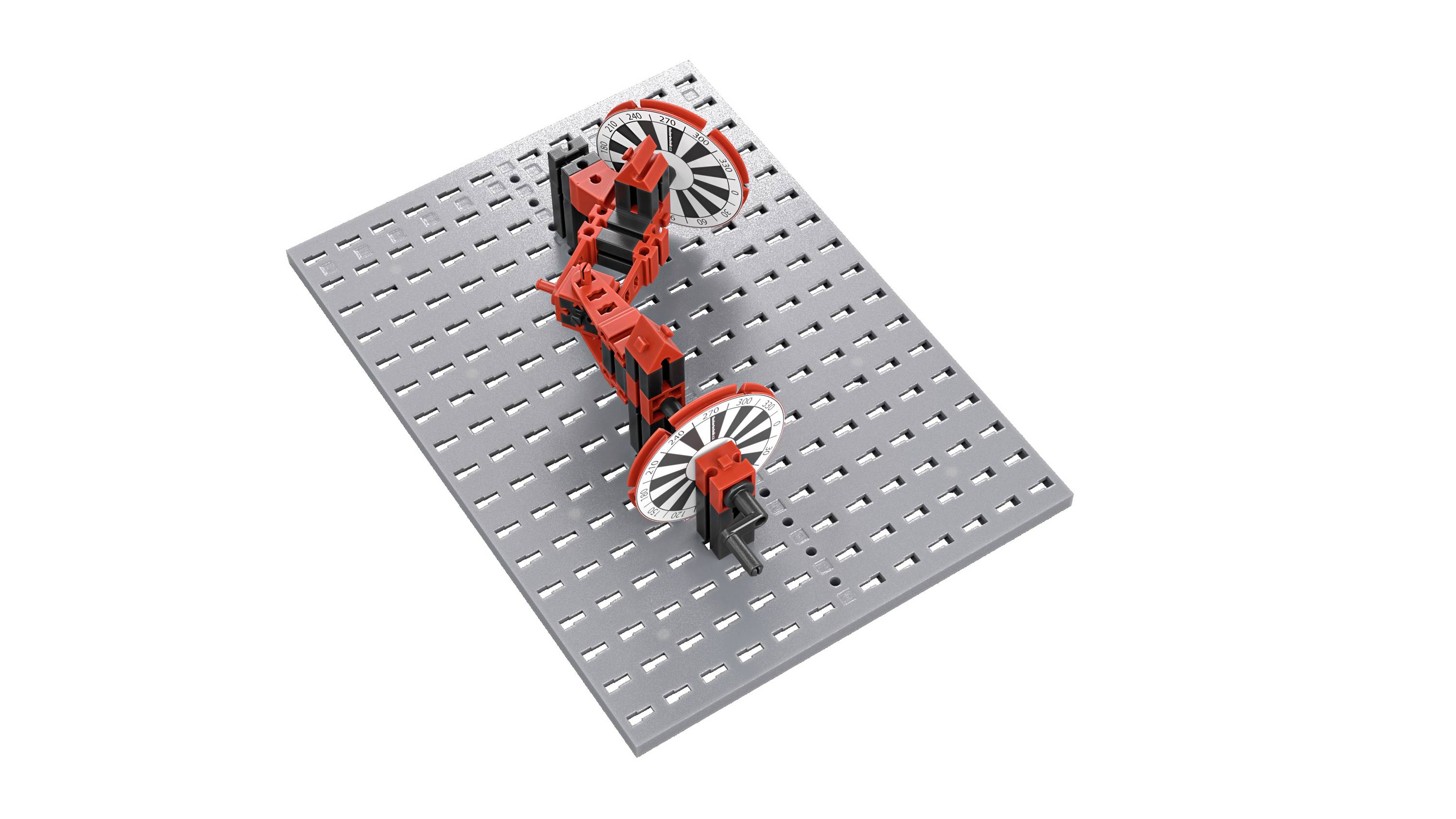 Mechaniczny model z czerwonymi i czarnymi elementami, wyposażony w dwie duże koła na dziurkowanej podstawie.