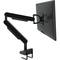 Czarny wysięgnik monitora z przegubami podtrzymuje płaski ekran zamocowany na biurku.