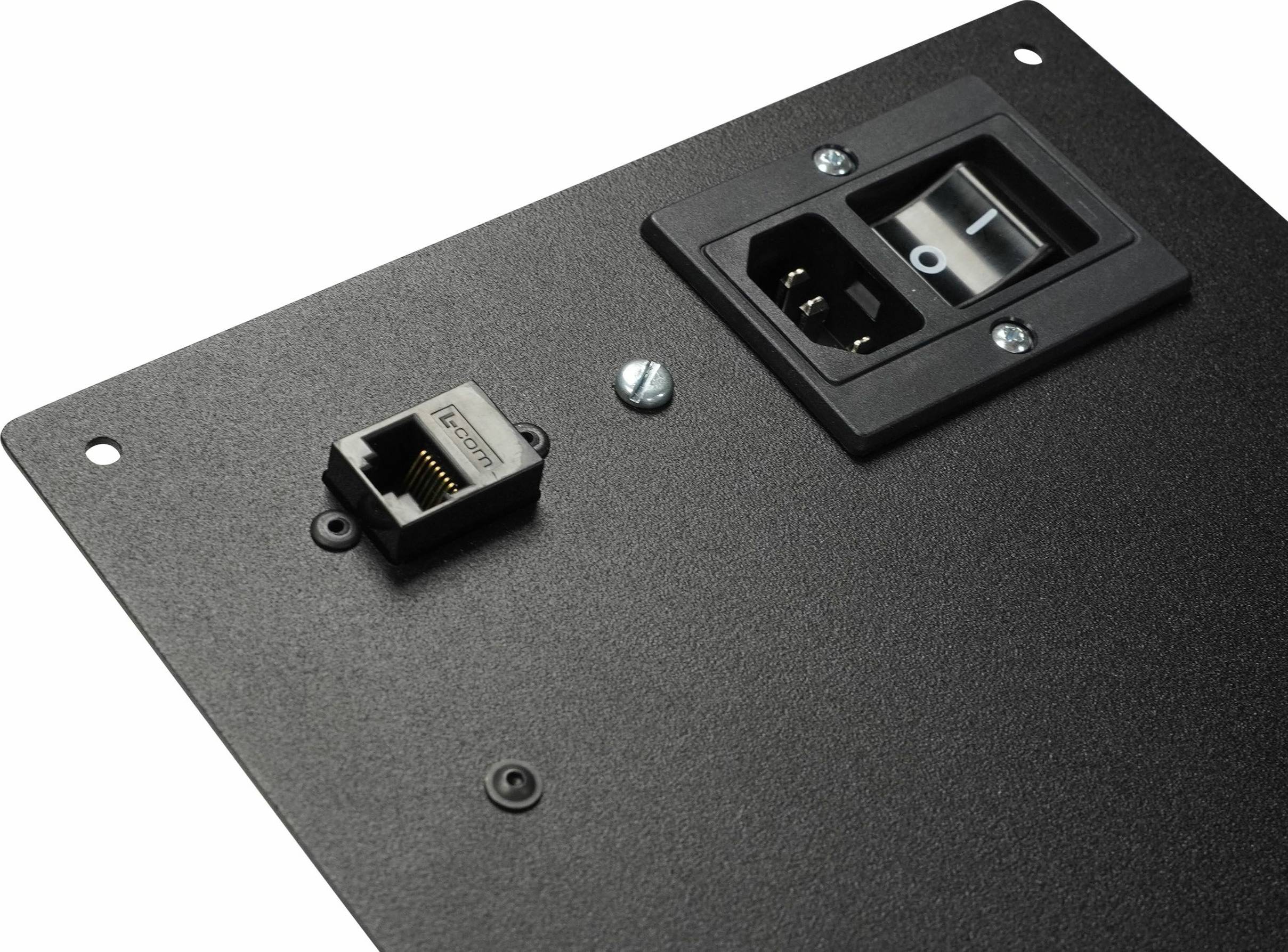Czarna metalowa płyta z włącznikiem sieciowym, złączem zasilania i portem Ethernet.