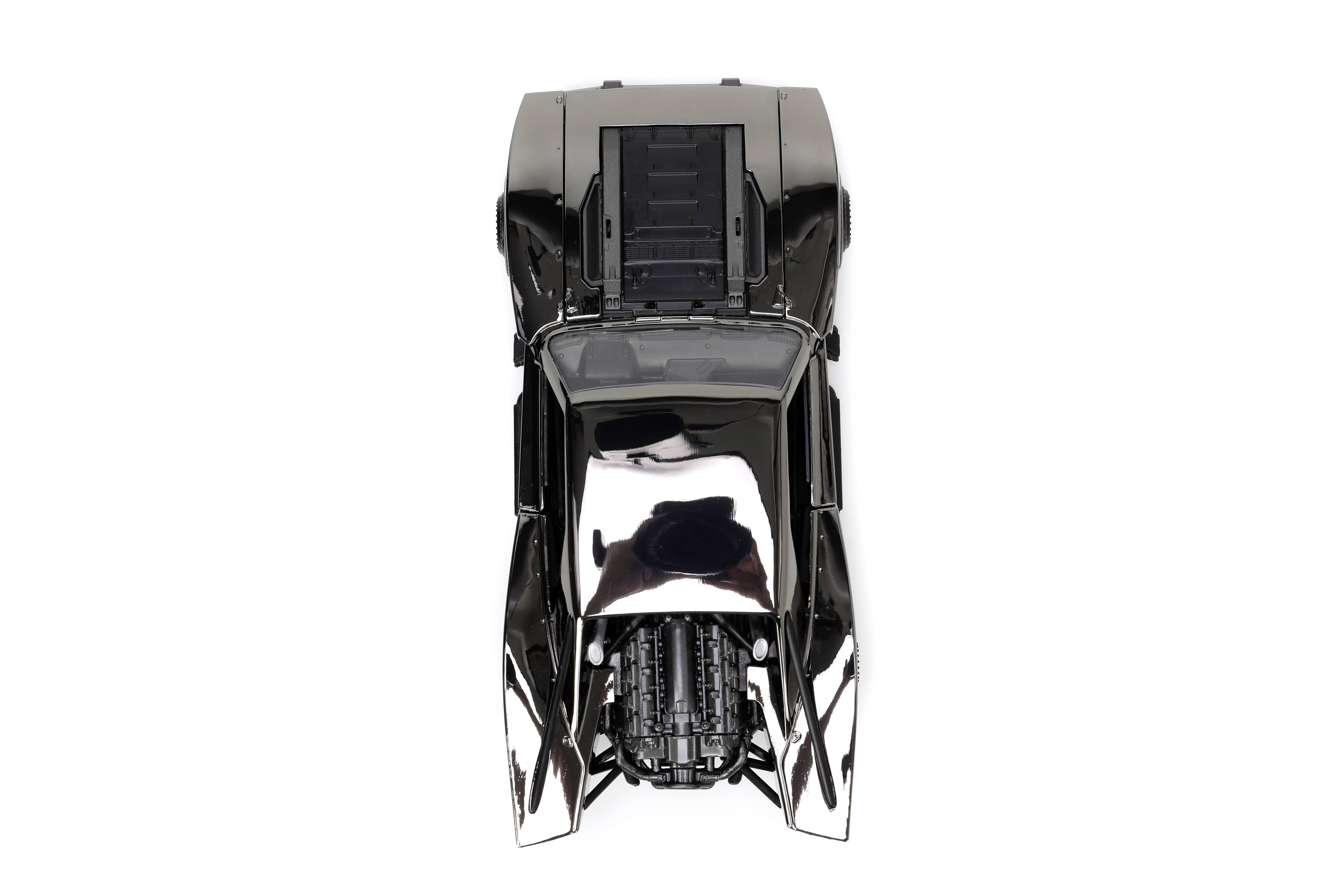 Lśniący czarny samochodzik zabawkowy widziany z góry, z widocznymi szczegółami silnika i opon na białym tle.