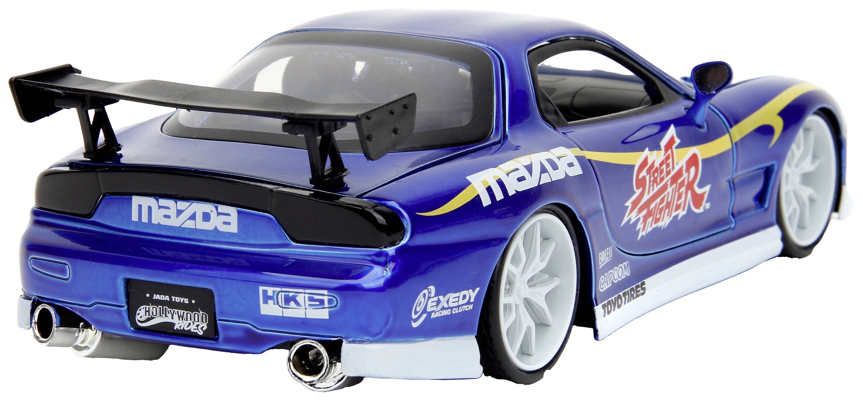 Niebieski model samochodu sportowego w stylu wyścigowym, z logo i grafikami na boku, dużym tylnym skrzydłem, białymi i niebieskimi felgami oraz dwoma końcówkami wydechu.