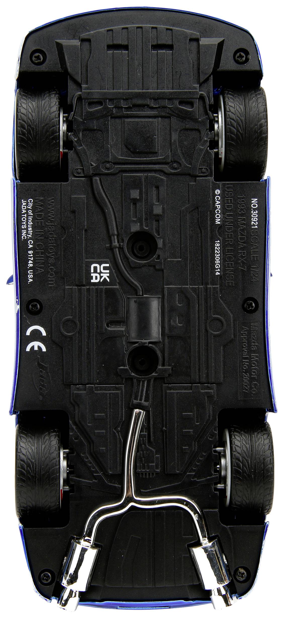 Niebieskie autko modelowe widziane od spodu, ukazujące szczegóły podwozia, kół i układu wydechowego.