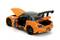 Pomarańczowy model samochodu z otwartą klapą bagażnika i maską silnika. Zabawkowy samochód posiada czarne koła i duży tylny spoiler.