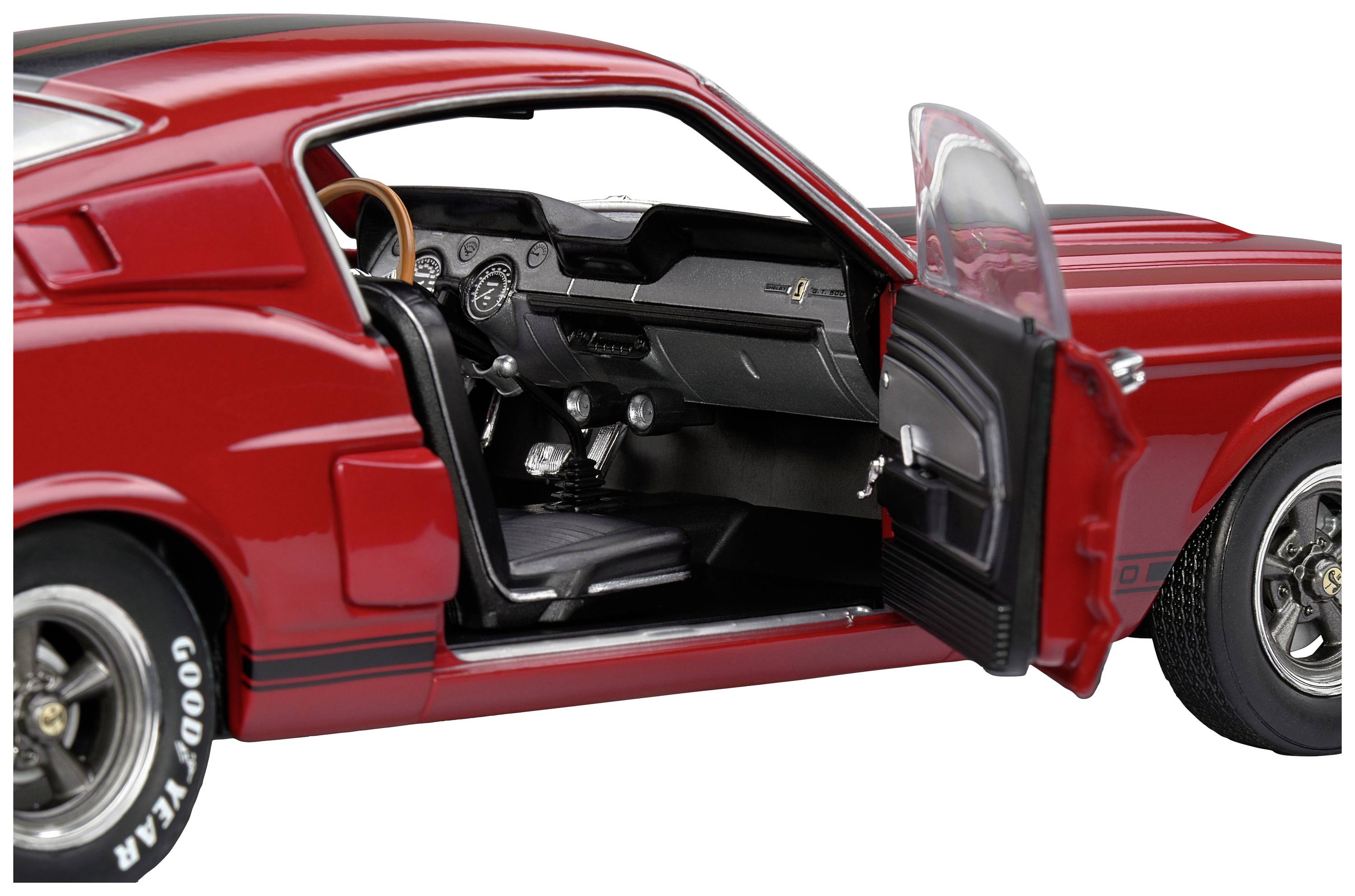 Czerwony zabytkowy samochód z otwartymi drzwiami kierowcy, ukazujący kierownicę i deskę rozdzielczą. Sportowy design, szczegółowy widok wnętrza.