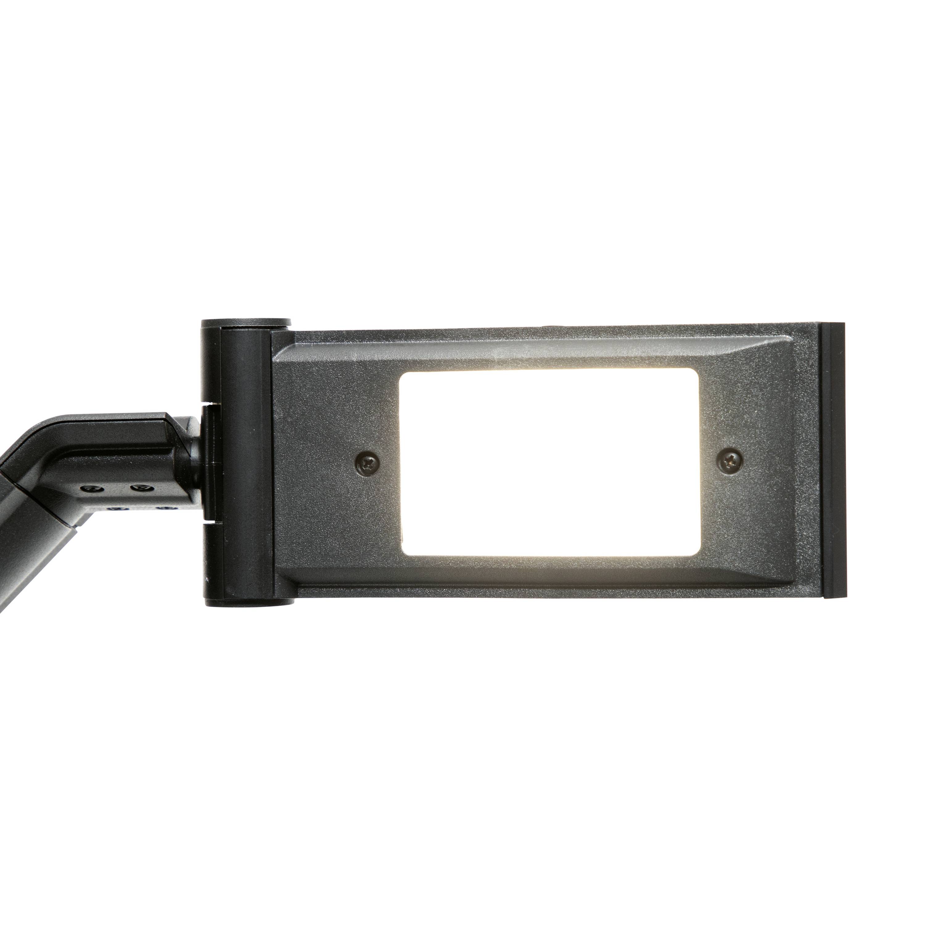 Prostokątna, nowoczesna czarna lampa LED świeci jasno. Jest zamontowana na regulowanym ramieniu.