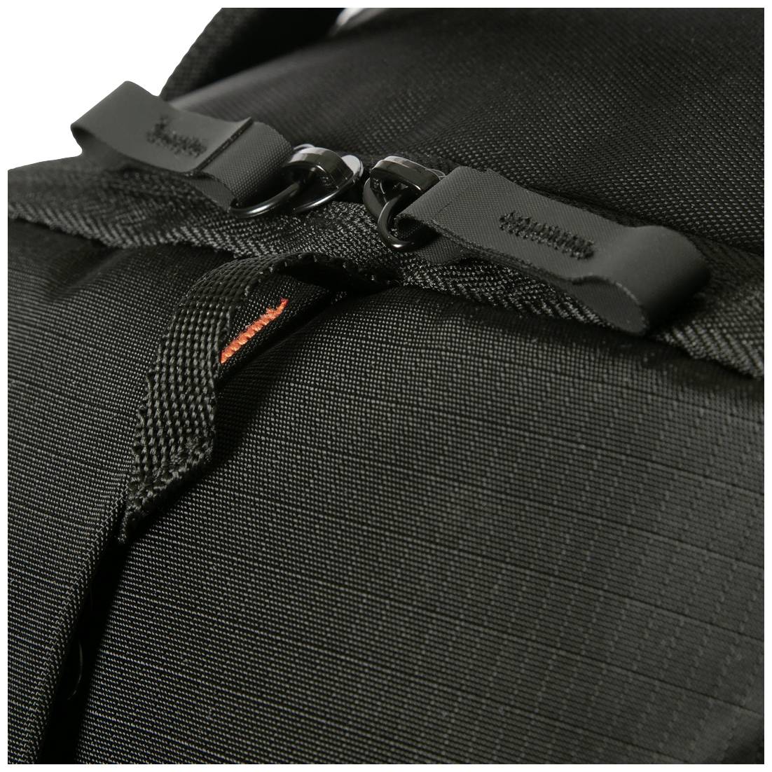 Zbliżenie czarnego plecaka z zamkami błyskawicznymi i wytrzymałego materiału, ze szczególnym skupieniem na dwóch czarnych uchwytach zamków.