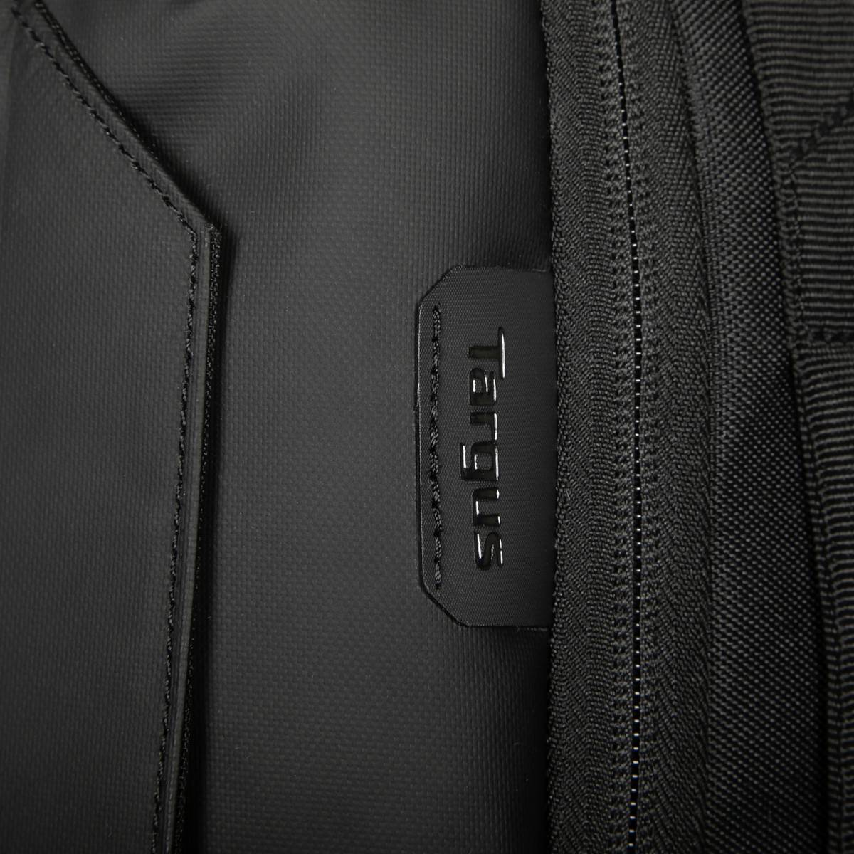 Zbliżenie czarnego plecaka z małą tabliczką z napisem 'Targus'.
