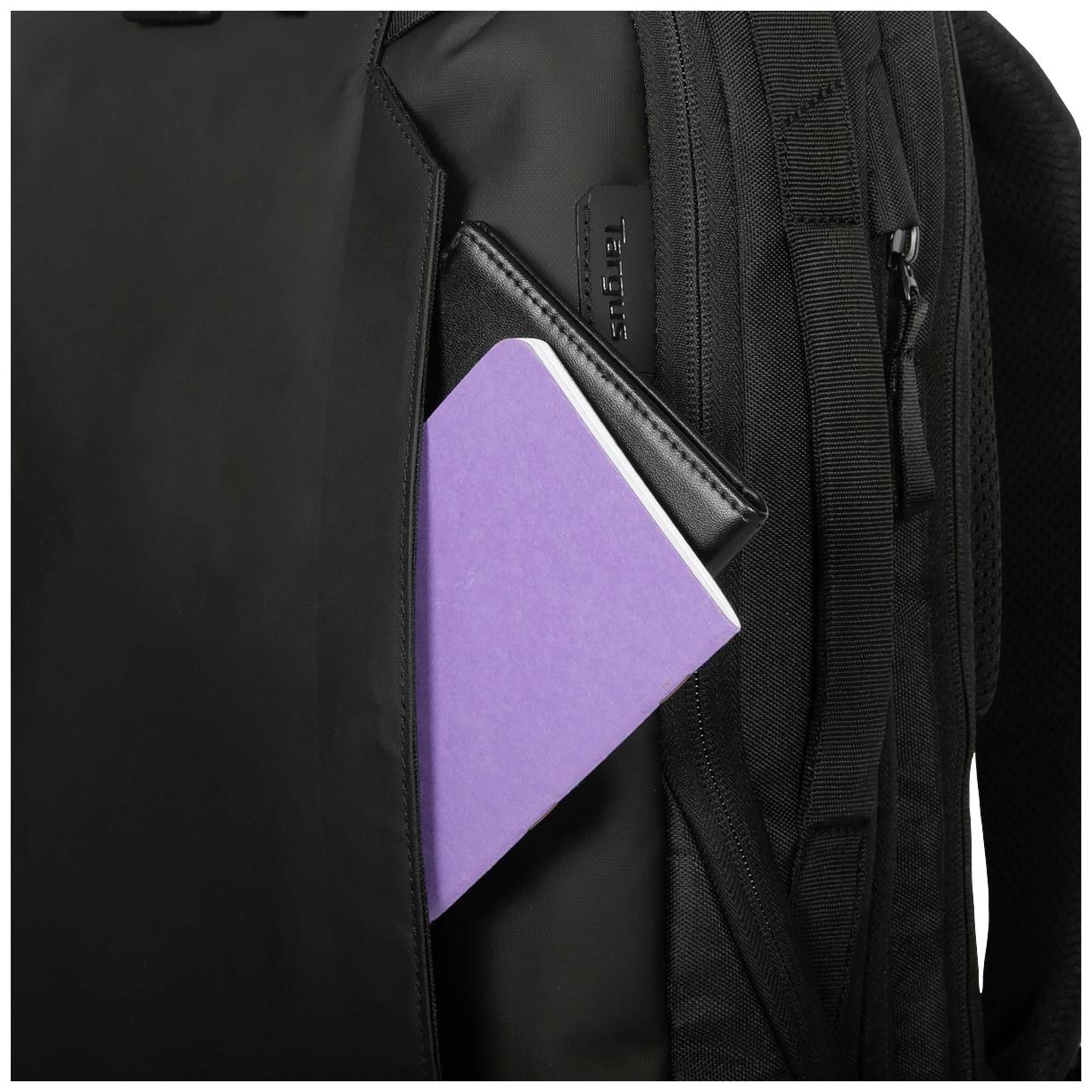 Czarny plecak z fioletowym zeszytem w bocznej kieszeni.