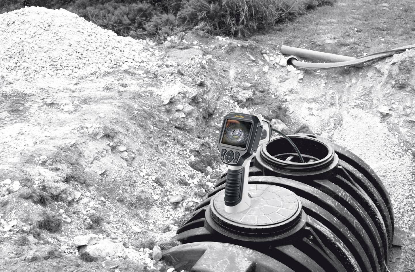 Kamera bada system kanalizacyjny w gruncie. Urządzenie jest umieszczone na otwartym szybie, aby sprawdzić strukturę wewnętrzną.