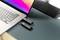 Laptop na stole z podłączonym pendrivem USB i kolejnym leżącym obok. W tle ciemny głośnik.