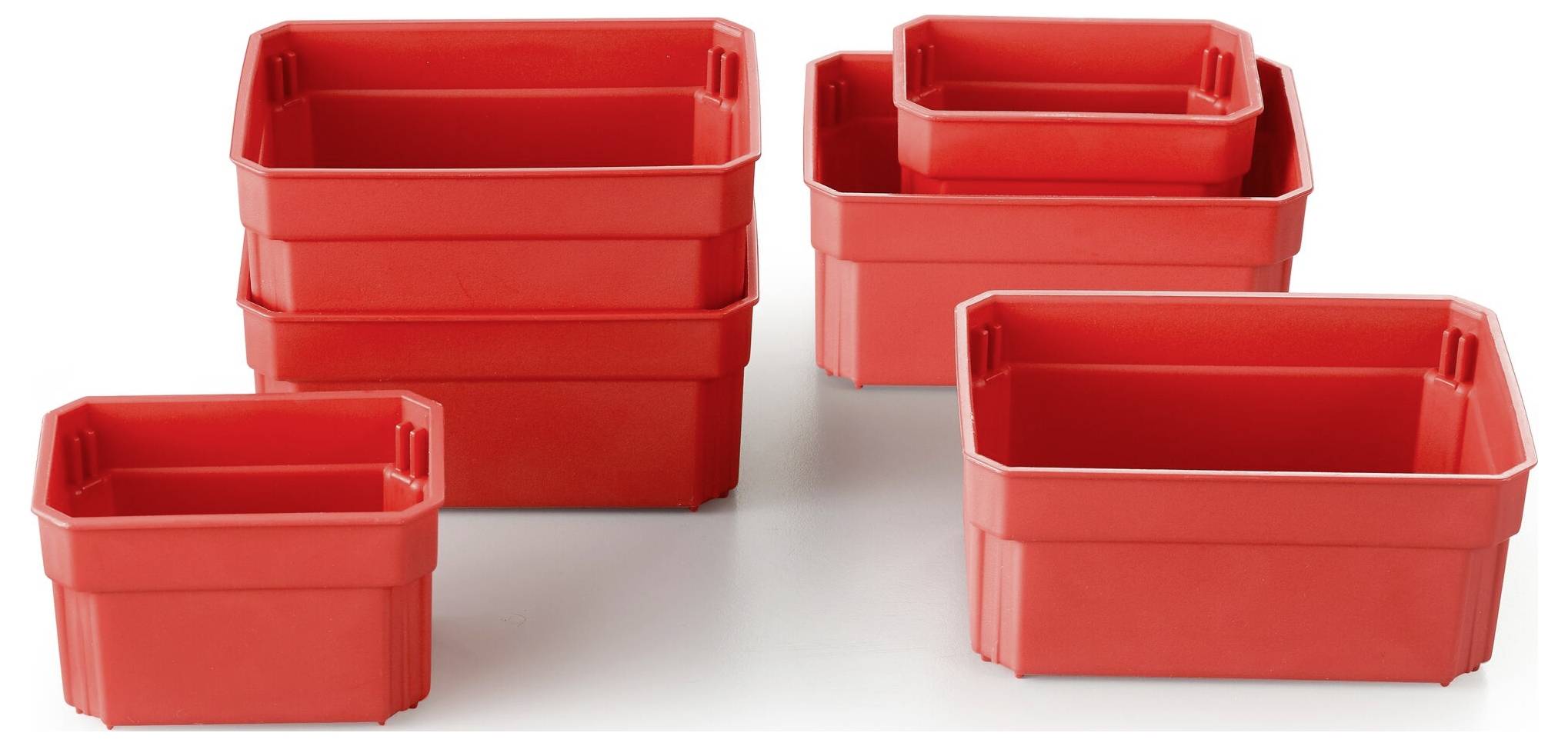 Czerwone plastikowe pojemniki o różnych rozmiarach, ułożone w stos i obok siebie na białym tle.