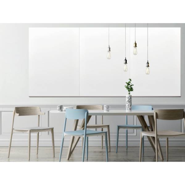 Nowoczesna jadalnia z białym stołem, niebieskimi i drewnianymi krzesłami, udekorowana rośliną w kratowanym wazonie. Nad nią wiszą żarówki.