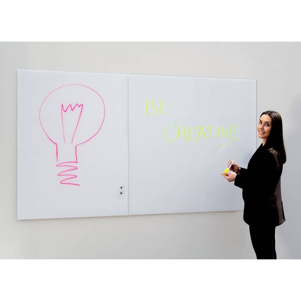 Kobieta stoi obok tablicy białej z napisem 'Bądź kreatywny' i narysowaną żarówką symbolizującą kreatywność.
