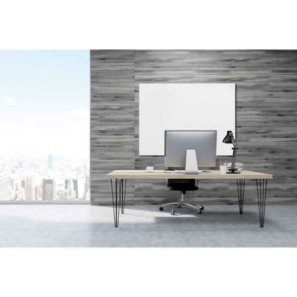 Nowoczesna przestrzeń biurowa z biurkiem, krzesłem, komputerem i lampą, przed dużym oknem z widokiem na miasto.