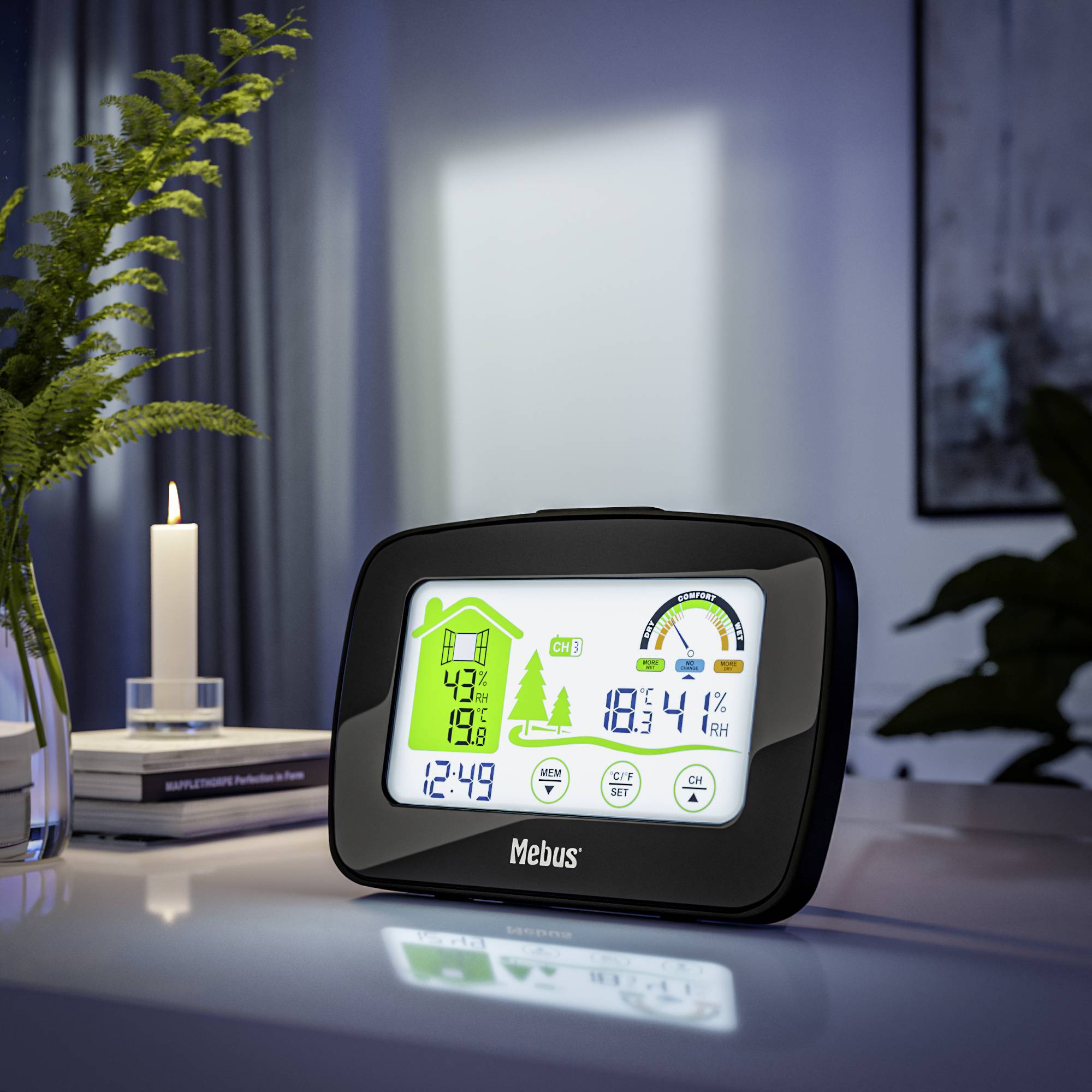 Cyfrowy budzik na stole wskazuje godzinę 12:43, wilgotność powietrza 43% i temperaturę 18,1°C. W tle płonie świeca.