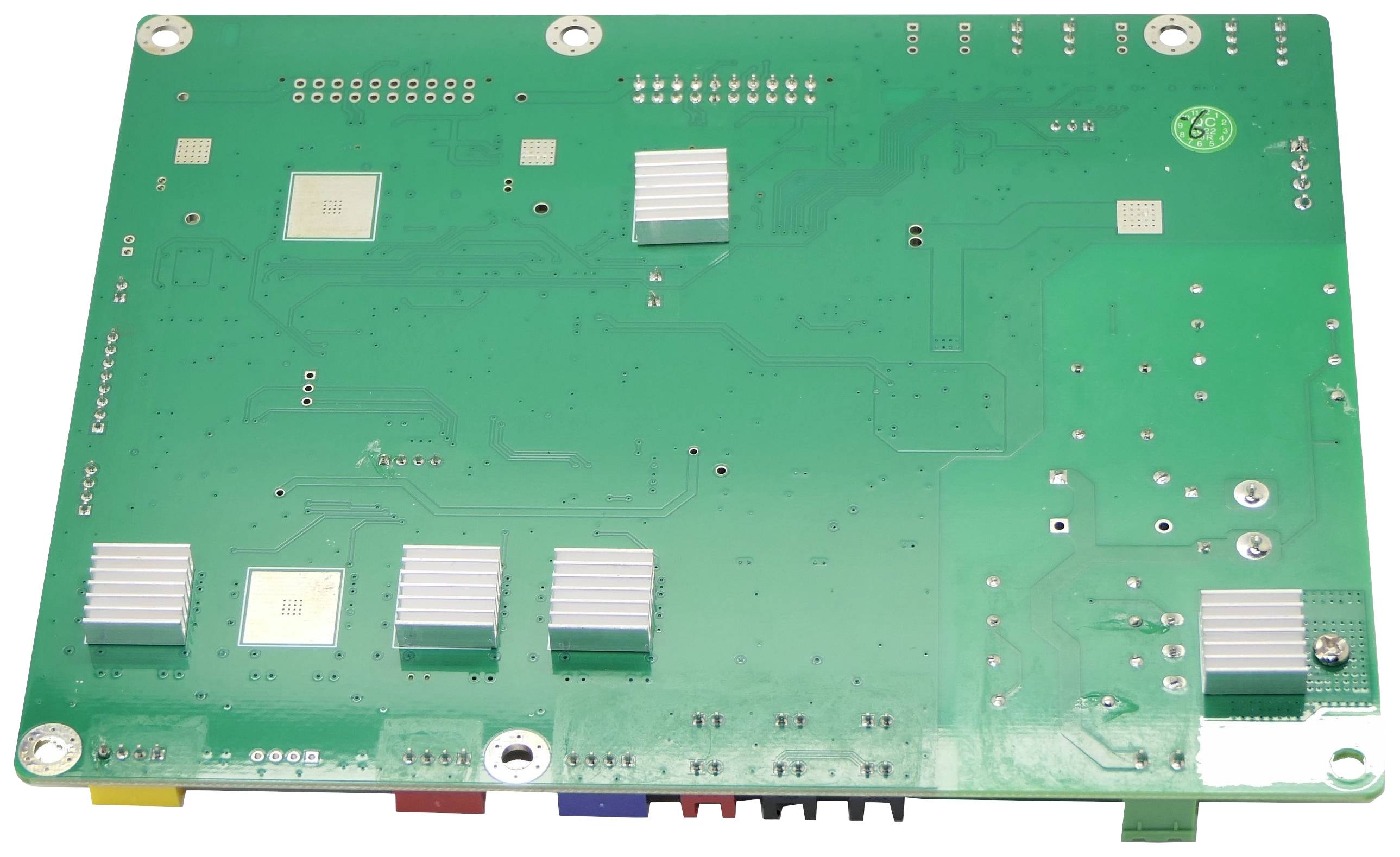 Płytka drukowana z różnymi elementami elektronicznymi i złączami na zielonym tle.